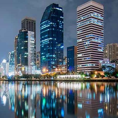 City skyline at night, reflected on water