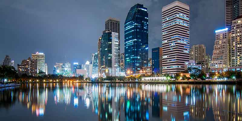 City skyline at night, reflected on water