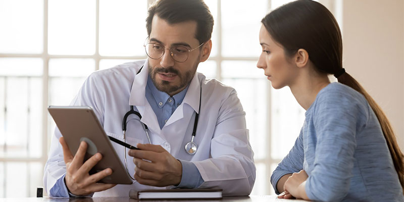 Doctor using tablet to show a form to a patient