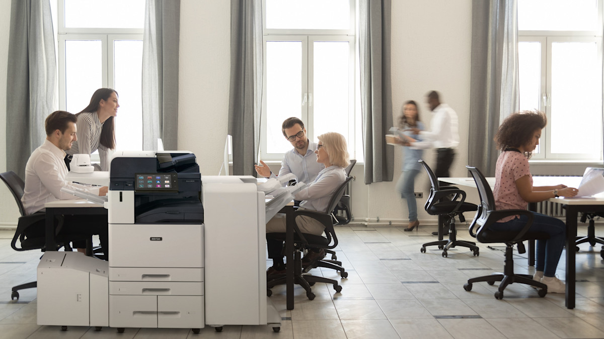 Colleagues meeting next to a Xerox AltaLink B8200 Series MFP