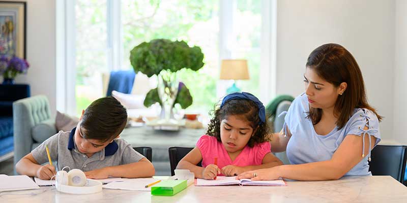 Mother helping her children with schoolwork