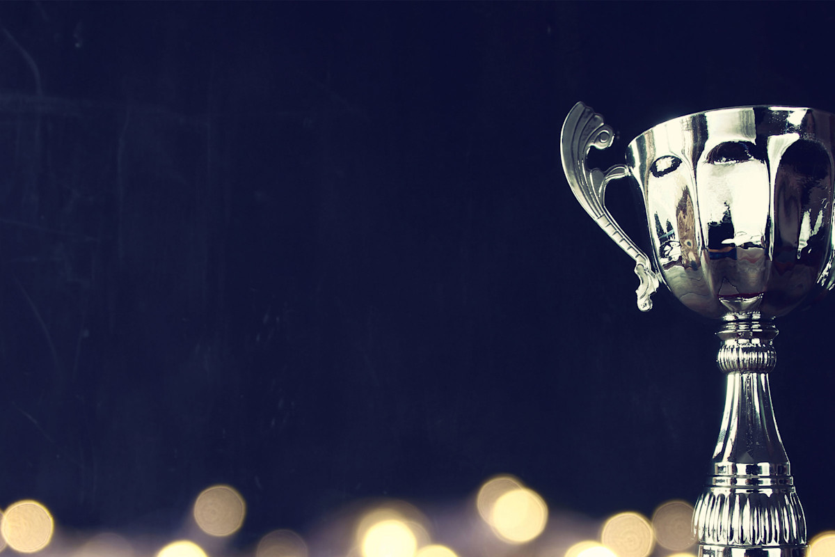 Silver trophy sitting on a glittery platform