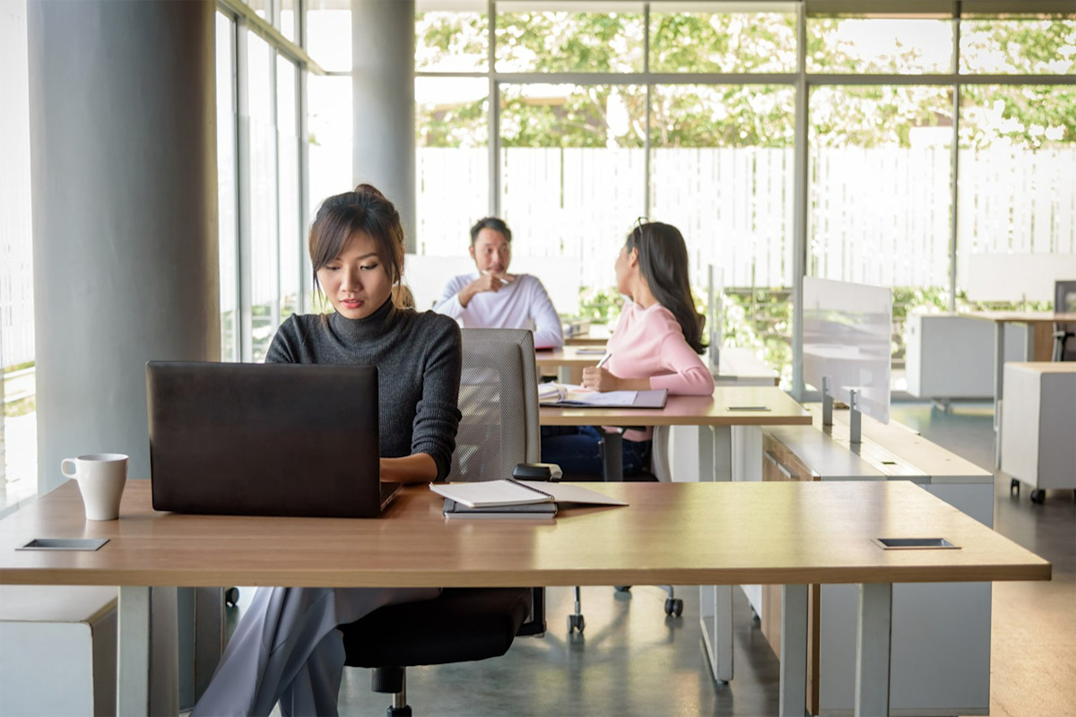 Woman working on a laptop in an open plan office