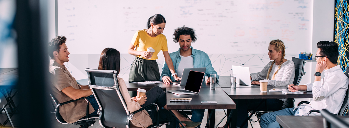 Co-workers working together at a jumble of desks